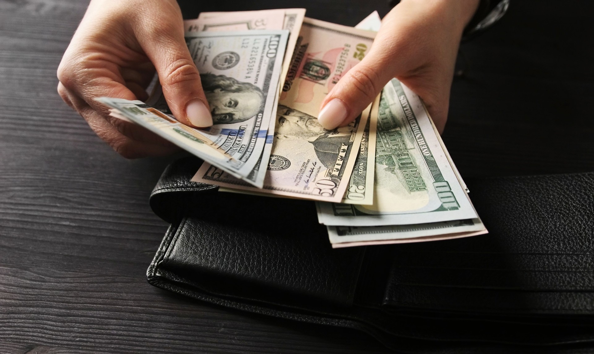 Woman Counting Her Cash Savings In Usa Dollar Bills
